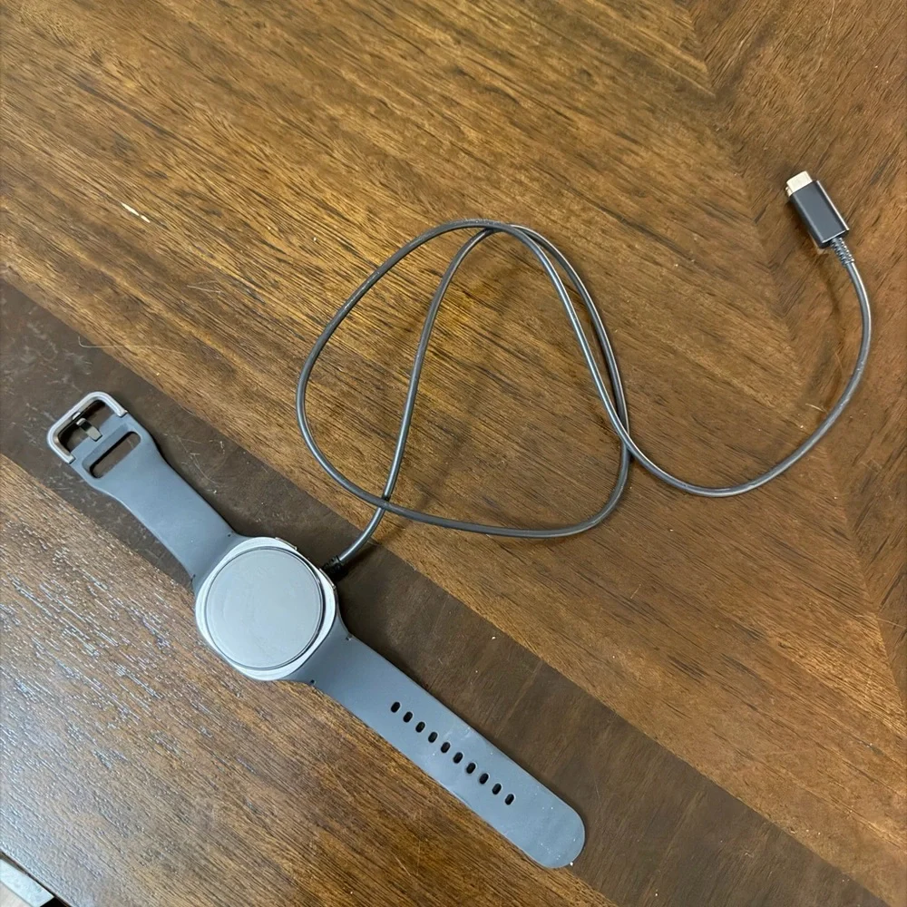 Samsung Smartwatch with Gray Band and Charging Cable